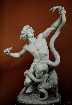 a statue of a man holding a snake