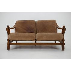 a brown couch sitting on top of a wooden frame