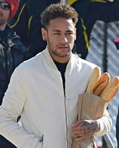 a man holding bread in his hand while wearing a white jacket