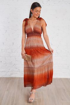 Dazzle in this sophisticated tulle layered maxi dress. This in-store bestseller is crafted with an ombre rust metallic fabric and has a deep v plunge on the front and back. This chic dress features a flattering empire waistline and self tie ribbons on the shoulders, making it the perfect dress for all your fall festivities. It has a full length liner, an elastic waistband, is non-sheer, and fits true to size. A luxurious must-have for any special occasion, you'll shine with effortless elegance! Layered Maxi Dress, Shine Dress, Fall Festivities, Empire Waistline, Metallic Fabric, Effortless Elegance, Fall Festival, To Shine, Chic Dress