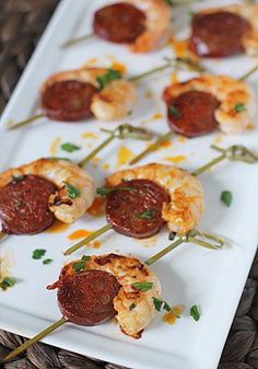 small appetizers are arranged on a plate with toothpicks