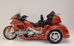 an orange toy motorcycle is shown on a white background