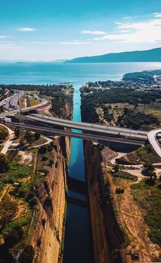 an aerial view of a bridge over a body of water with cars driving on it