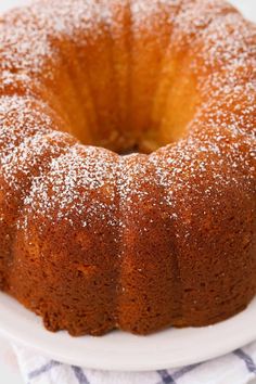 a bundt cake with powdered sugar on top sits on a white platter