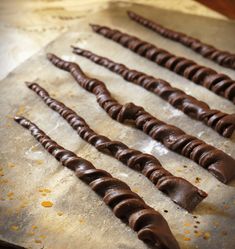 chocolate sticks are lined up on a baking sheet