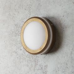 a light that is on the side of a wall with a white and gold trim