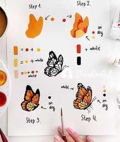 someone is painting butterflies on a piece of paper with paint and watercolor pencils