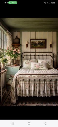 a bed sitting in a bedroom next to a window with flowers on top of it