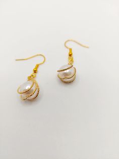 Beautiful hand made gold twisted artificial pearl drop earrings. Great for any occasion. Elegant Gold Wire Wrapped Teardrop Earrings, Elegant Gold Wire Wrapped Pearl Earrings, Elegant Gold Pearl Earrings Wire Wrapped, Gold Wire-wrapped Pearl Earrings, Gold Wire Wrapped Pearl Earrings, Gold Pearl Teardrop Earrings Gift, Gold Pearl Earrings With Wire Wrapped Detail, Pearl Drop Earrings, Pearl Drop