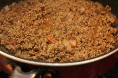 a pot filled with meat and vegetables on top of a stove burner in the oven