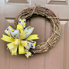 a yellow and white wreath on a door with polka dot ribbon hanging from the front