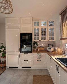 a kitchen with white cabinets and wooden counter tops