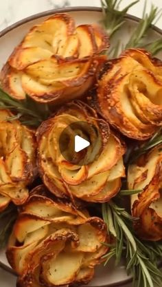 an image of baked potatoes on a plate with rosemary sprigs and seasoning