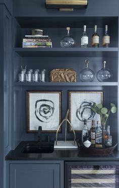 the shelves in this kitchen are filled with bottles and glasses