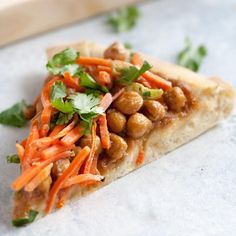 a slice of pizza topped with carrots and chickpeas