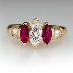 an engagement ring with two pear shaped ruby stones and baguettes on each side