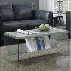 a glass table with books on it in front of a couch