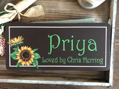 a sign that says priya is loved by christ morning and sunflowers on it