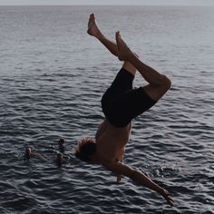 a man doing a handstand in the water