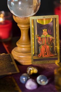 a tarot card sitting on top of a table next to some crystal balls and candles