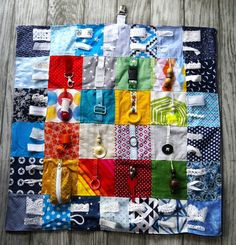 a multicolored patchwork quilt with scissors and other items on it sitting on a wooden surface