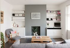 a living room filled with furniture and a fire place next to a wall mounted tv