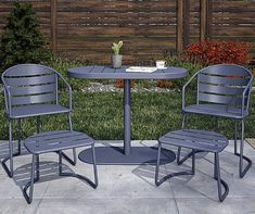 two chairs and a table in the middle of a yard