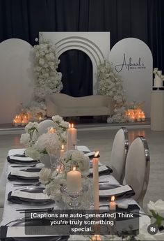 the table is set with white flowers and candles for an elegant dinner party or special event