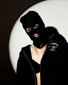 a person wearing a black mask and jacket