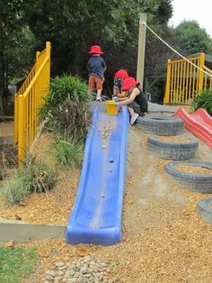 two children playing on a playground slide