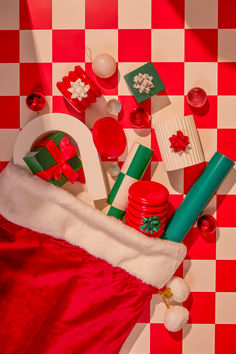 a santa claus hat and other christmas items on a checkered tablecloth with red and white squares