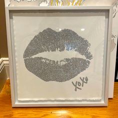 a white frame with silver glitter lips on it