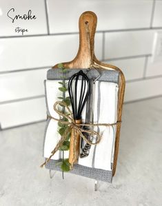 a kitchen utensil holder with an olive branch and whisk in it