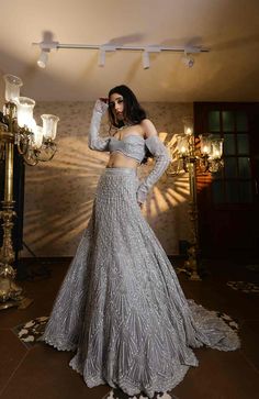 This striking silver lehenga set features all over sequin, crystal, cutdana embroidery in an A-line fit. Paired with an embroidered off shoulder blouse and matching dupatta.From Isa by Dolly Wahal's Fiori collection.DELIVERY TIMEPlease allow 8-12 weeks for your outfit to arrive.FABRIC DETAILSNetProfessional cleaning only. Silver Lehenga, Cutdana Embroidery, 12 Weeks, Skirt Length, Off Shoulder Blouse, Lehenga, Off Shoulder, Sequin, A Line