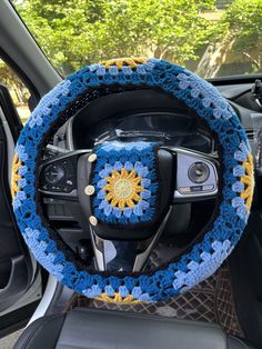 the steering wheel cover is crocheted with blue and yellow yarn