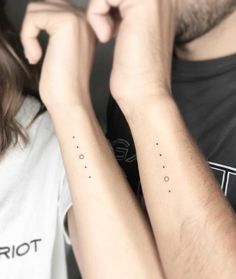 two people with matching tattoos on their arms