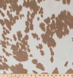 a brown and white spotted animal print fabric with a ruler in front of the image