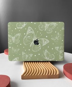 an apple computer sitting on top of a wooden stand next to some circles and dots