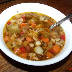 a white bowl filled with soup on top of a wooden table