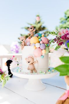 there is a cake decorated with balloons and teddy bears