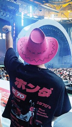 a man wearing a pink cowboy hat at a concert