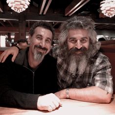 two men sitting next to each other at a table