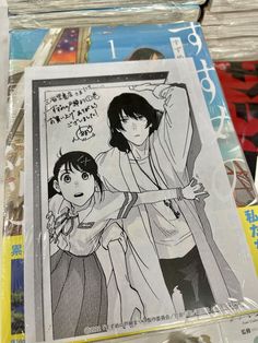 an image of two anime characters on the back of a book shelf with other books