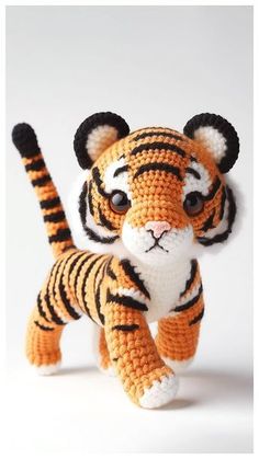 a crocheted stuffed animal that looks like a tiger is standing on its hind legs