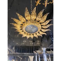 a gold sunflower chandelier hanging from the ceiling in a room with chandeliers