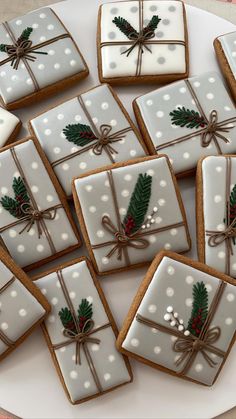 many decorated cookies on a plate with bows and holly leaves tied around the top one