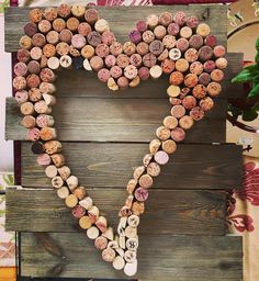 a heart made out of wine corks sitting on top of a wooden pallet