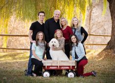 a family poses with their dog in front of a wagon