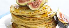 a stack of pancakes topped with figs and syrup