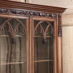 an ornate wooden cabinet with glass doors